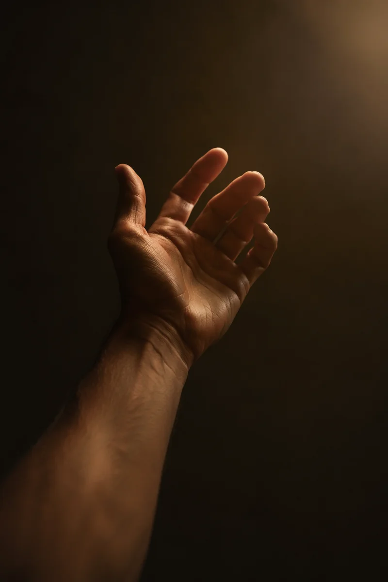 Hand Reaching Toward Warm Hopeful Light