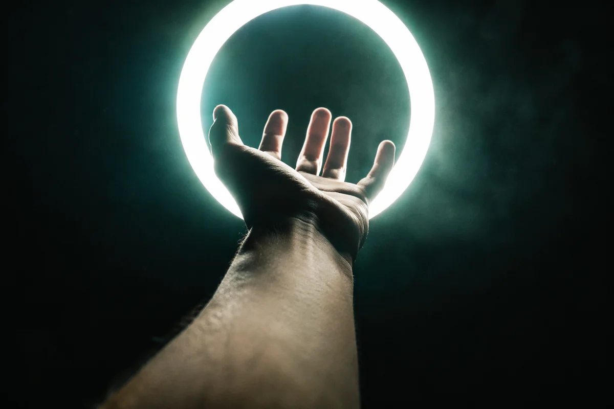Hand Reaching Toward Halo Light
