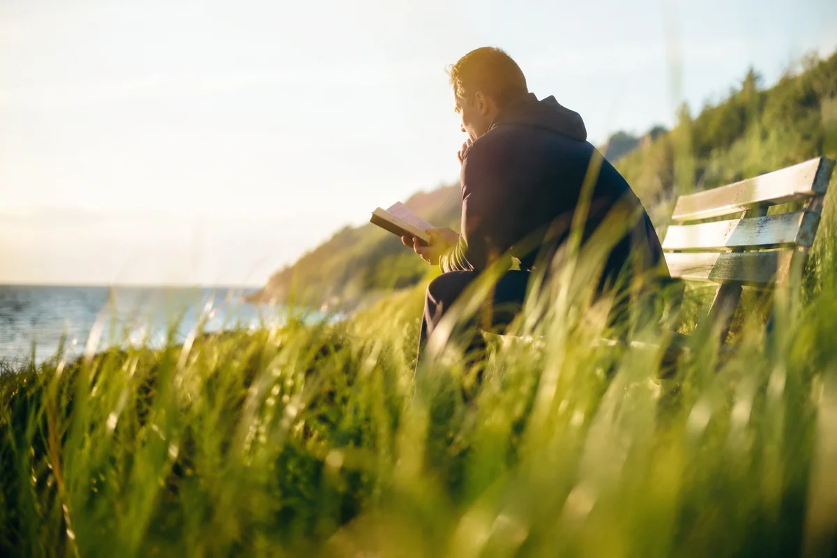 Man Reading Bible in Morning Coastal Light