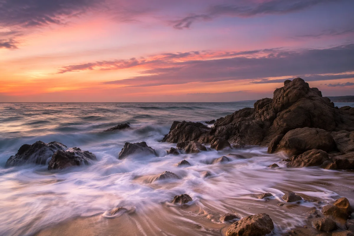Sunrise Waves Over Rocky Shoreline