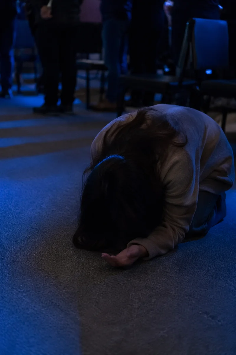 Kneeling Prayer in Quiet Community Gathering