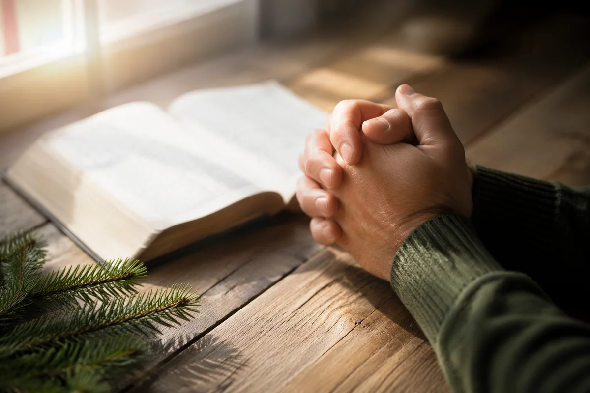 Praying Hands Beside Open Bible
