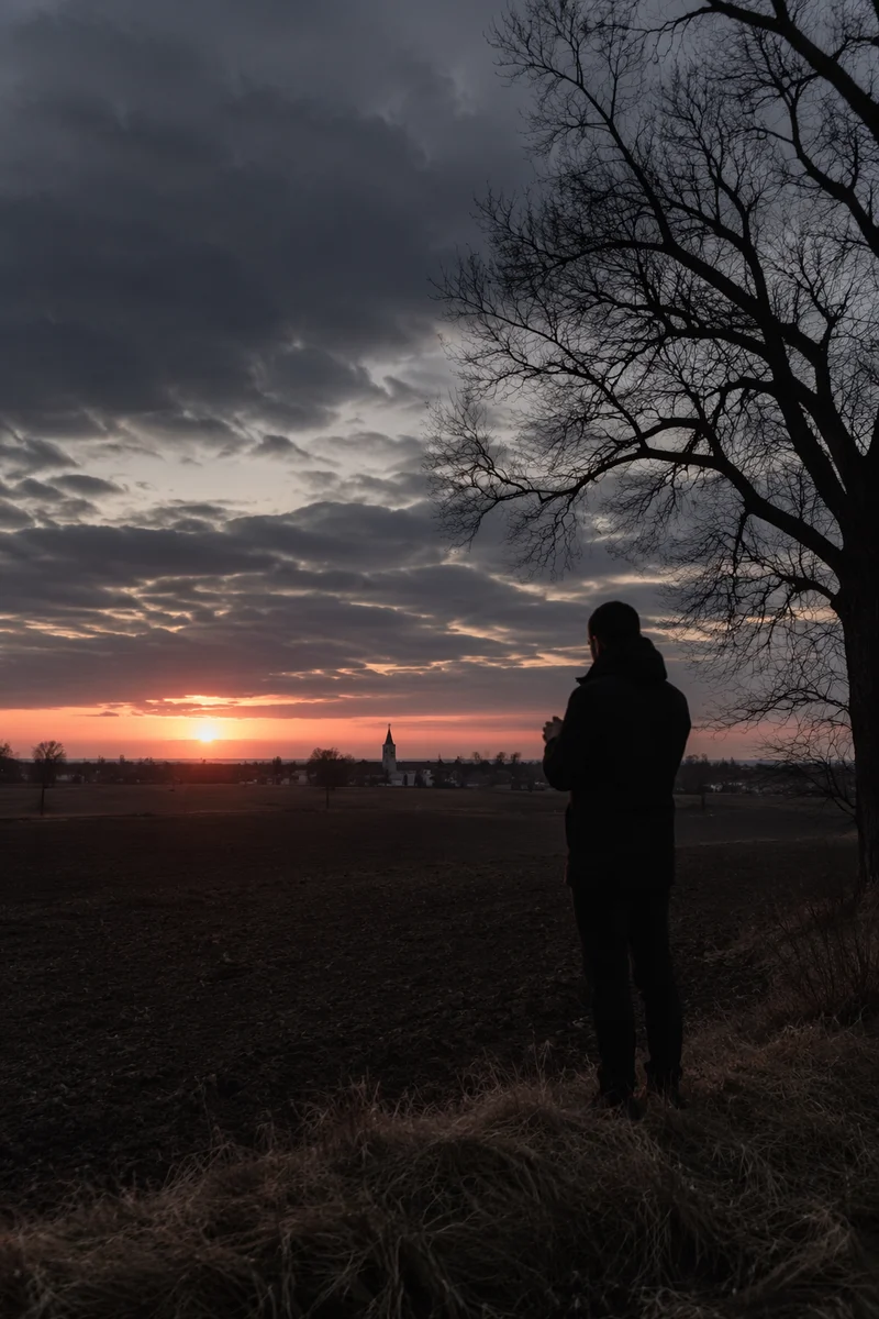 Silhouette Praying at Rural Sunset Sky