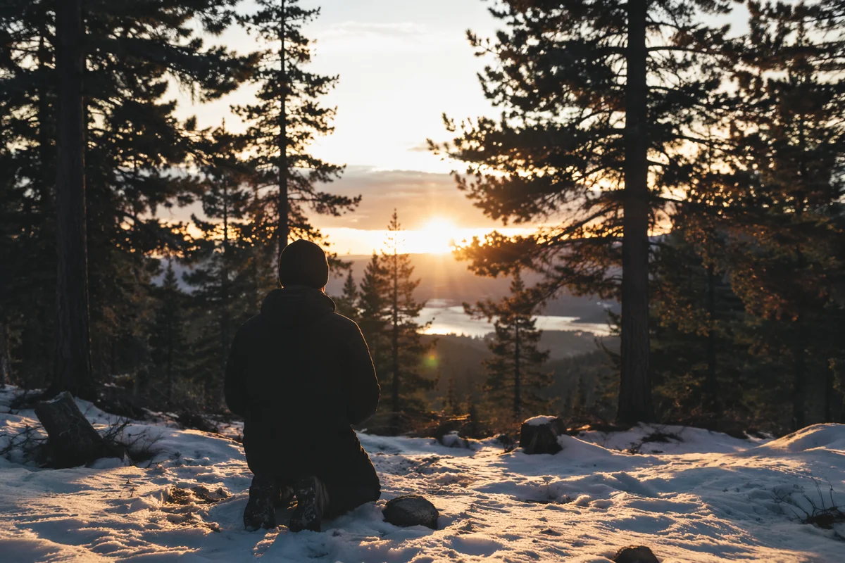 Silhouette Praying at Winter Evergreen Sunset