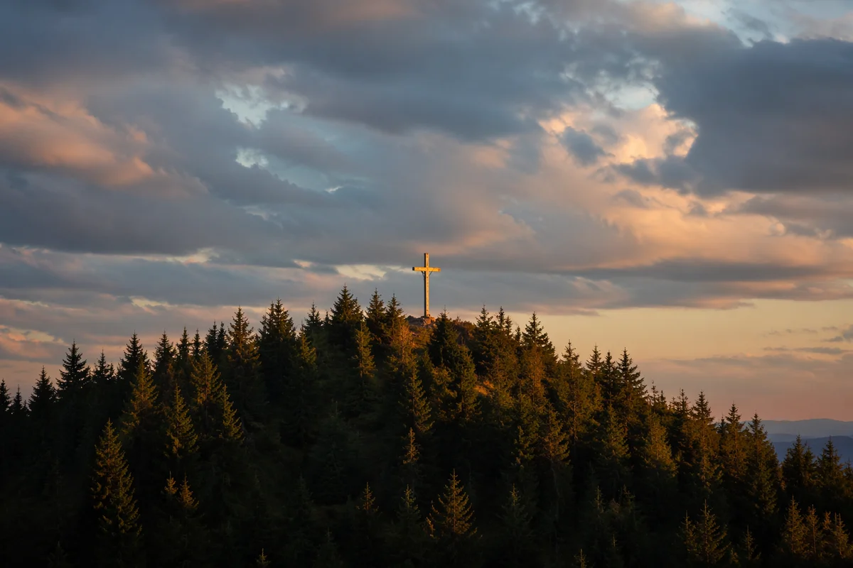 Wooden Cross on Evergreen Hill at Sunset