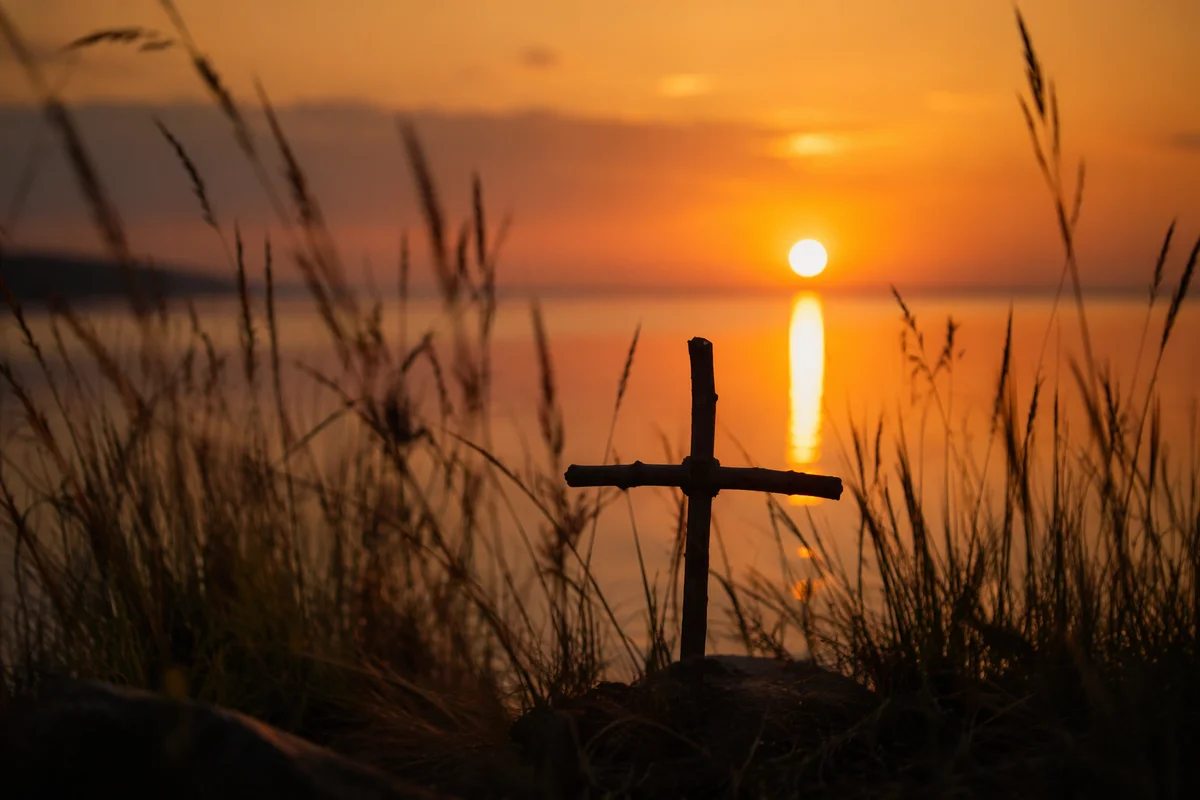 Rustic Wooden Cross at Sunrise Lakeshore