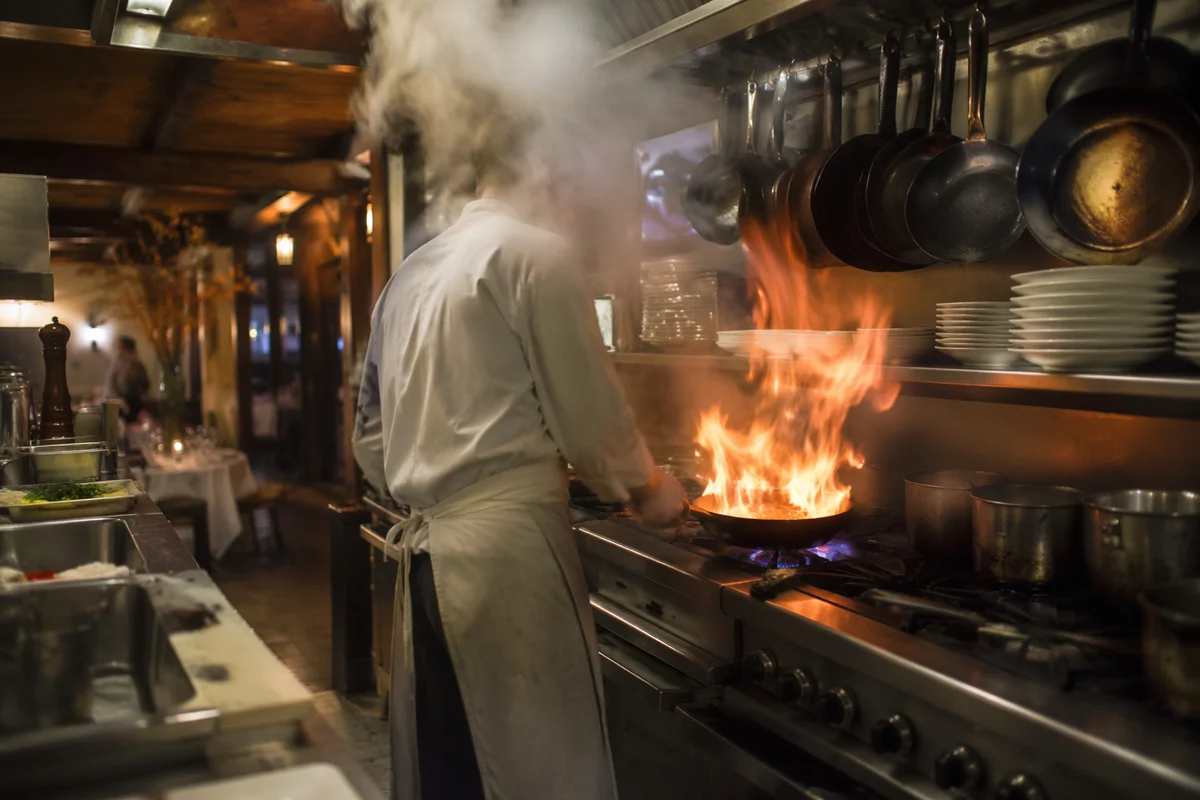 Chef Cooking Over Flame in Restaurant