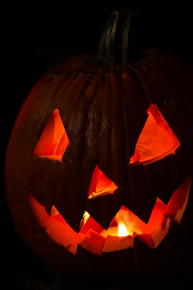 Glowing Carved Halloween Pumpkin in Darkness