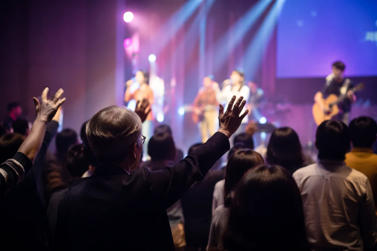 Raised Hands Facing Church Stage Lights