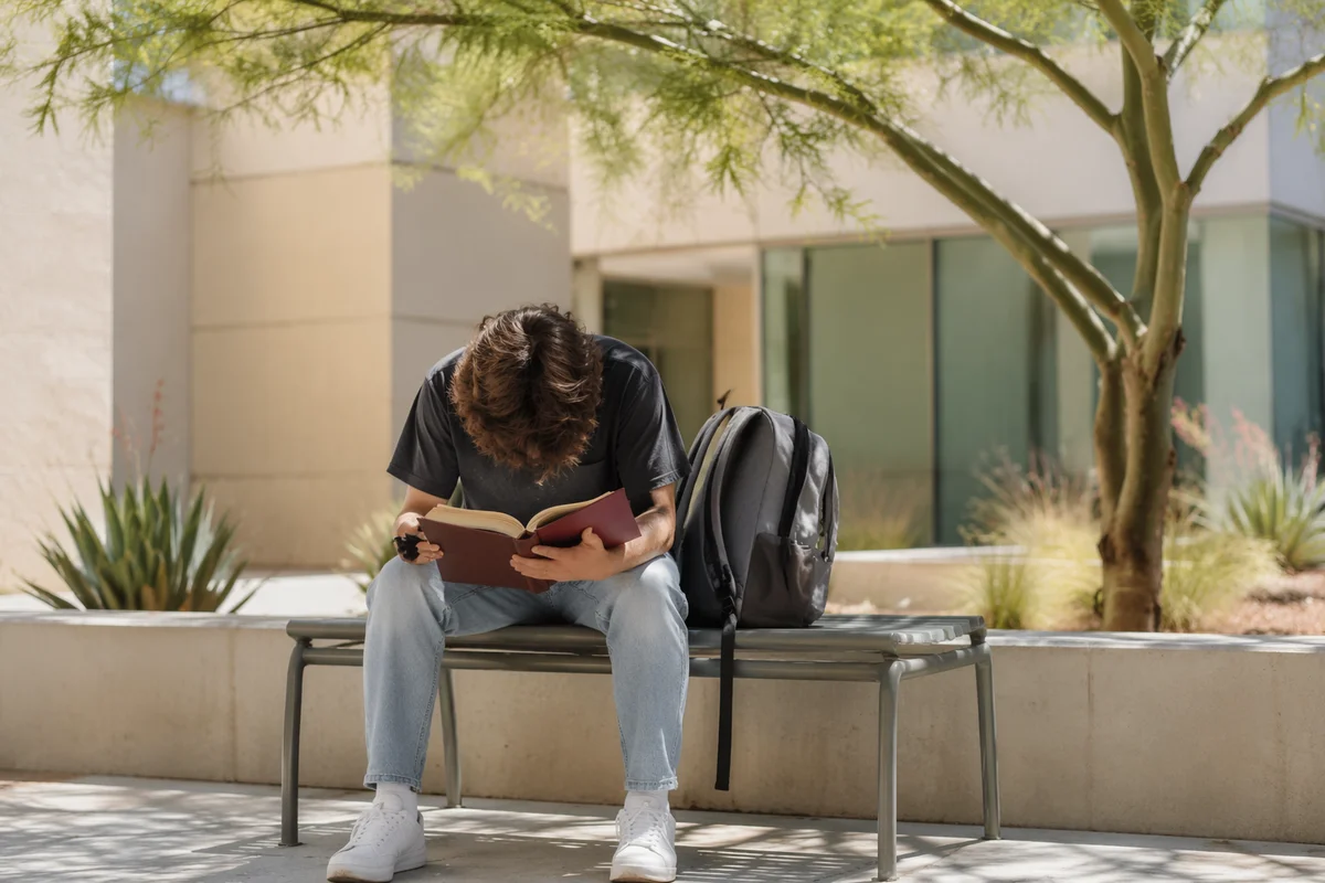 Student Reading Bible in Campus Courtyard