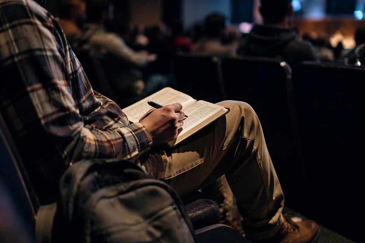 Student Reading Bible in Campus Lecture Hall