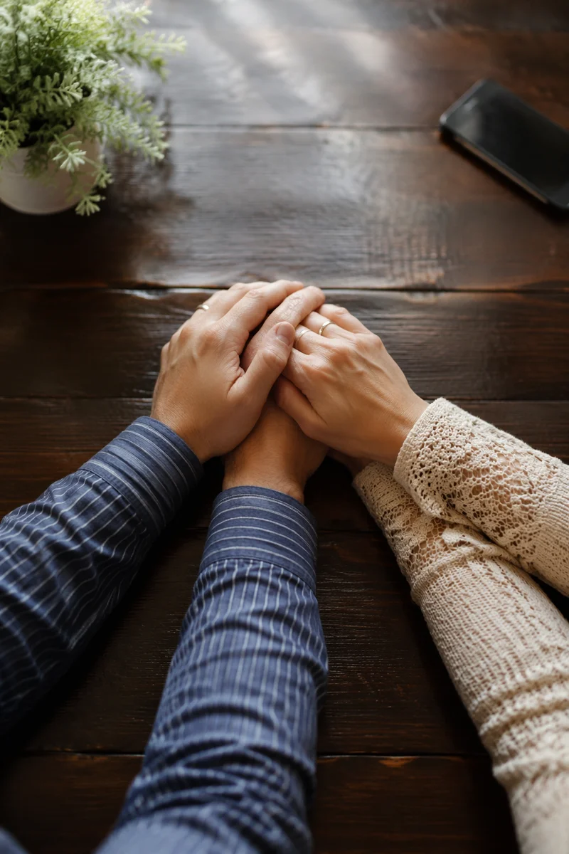 Couple Praying Hand in Hand at Table