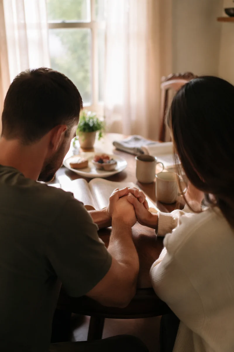 Couple Praying Together at Breakfast Table