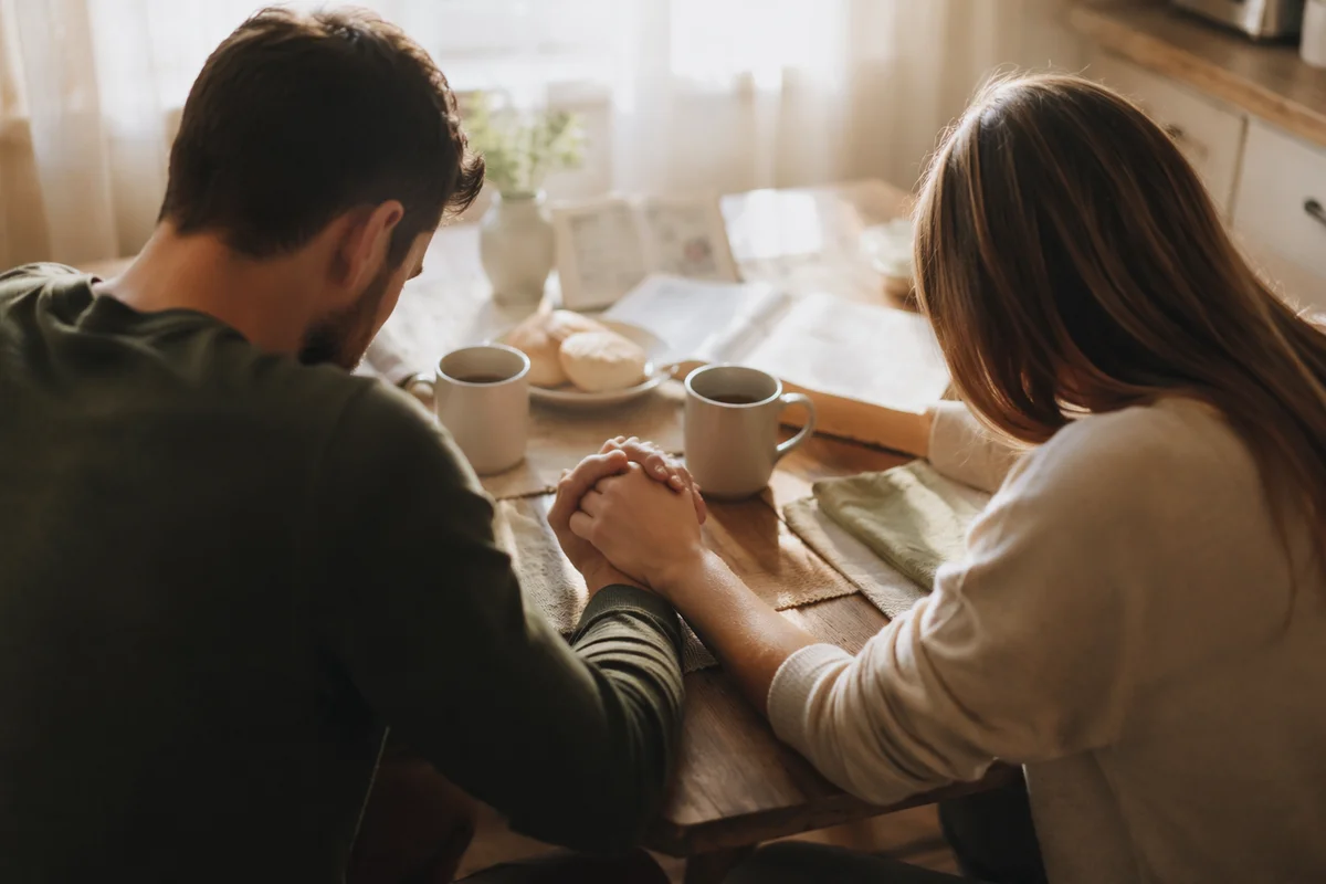 Couple Praying Together at Breakfast Table