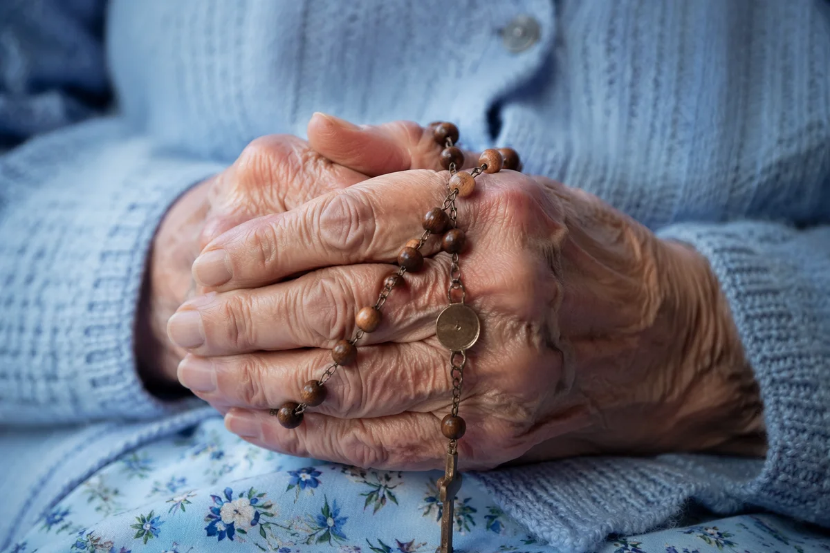 Elderly Hands Holding Rosary in Prayer