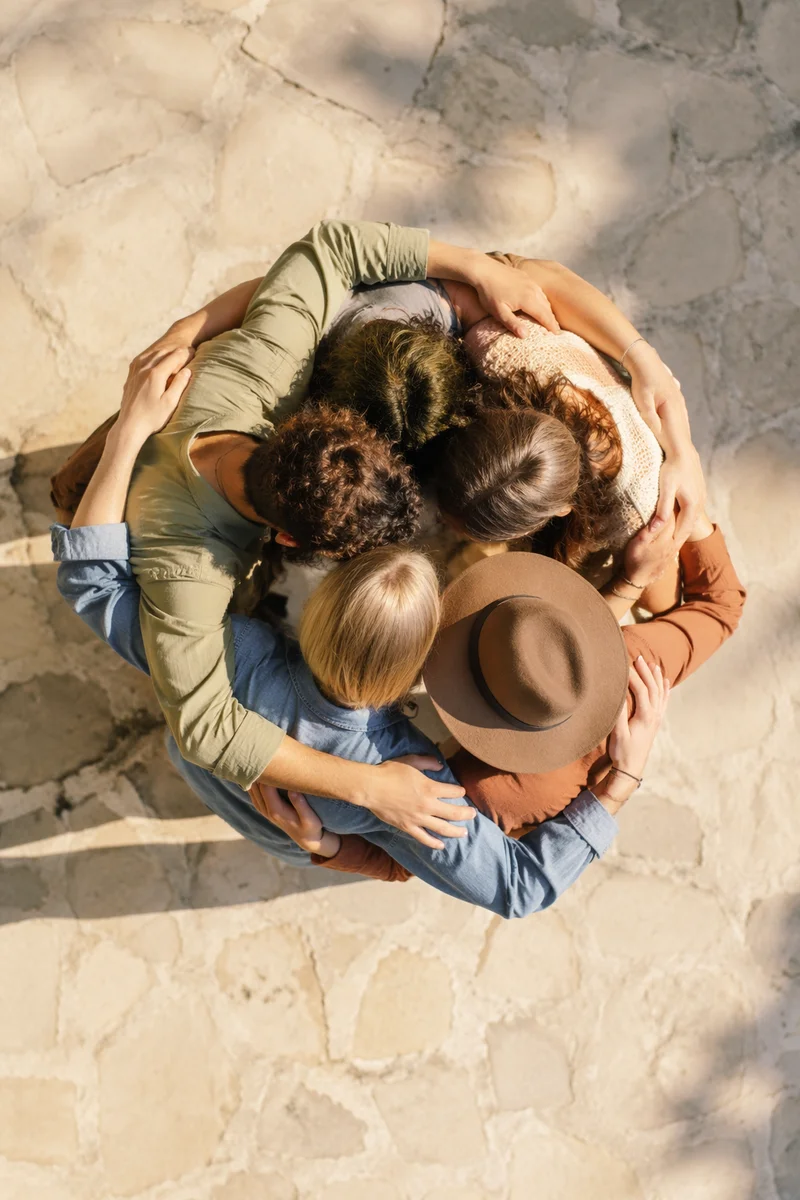 Overhead Friends Group Hug in Sunlit Courtyard