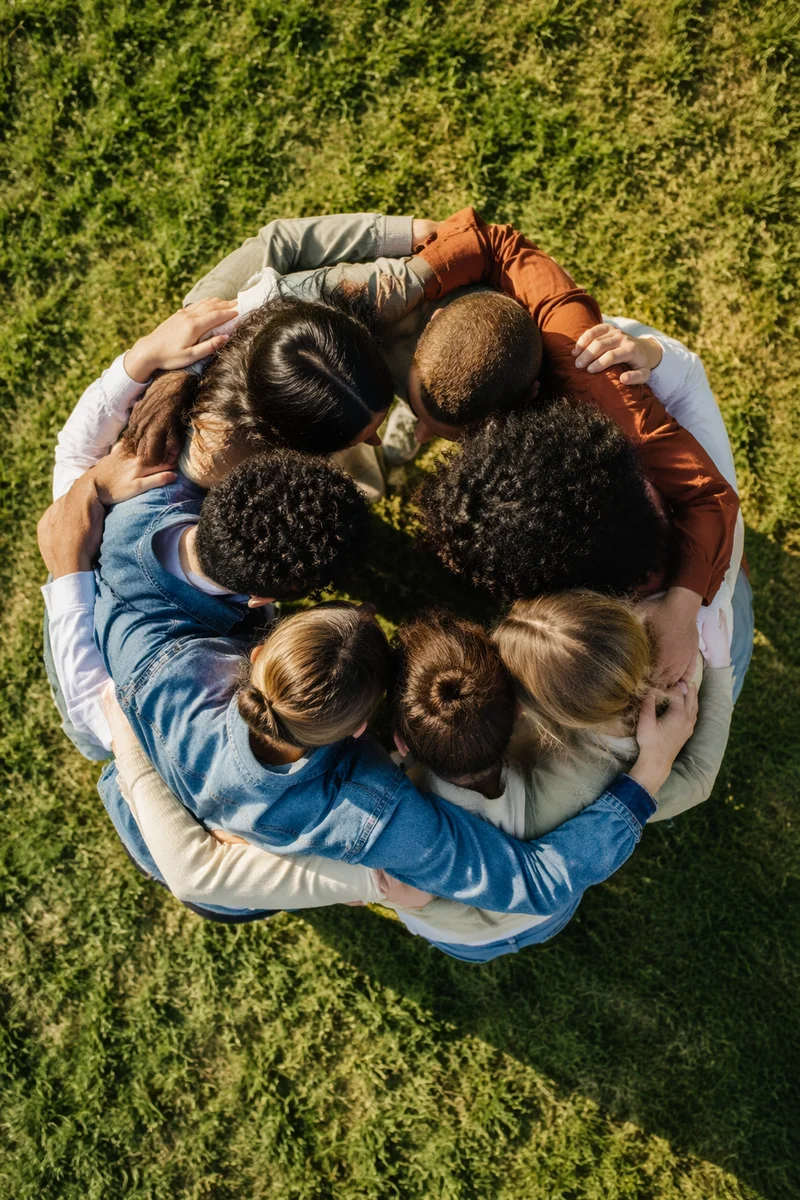 Overhead Friends Group Hug on Sunny Lawn
