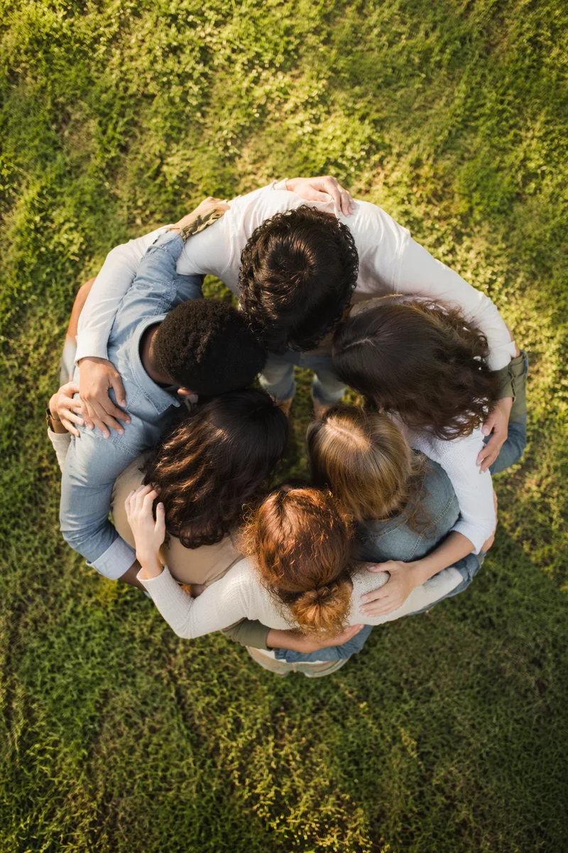 Overhead Friends Group Hug on Grass