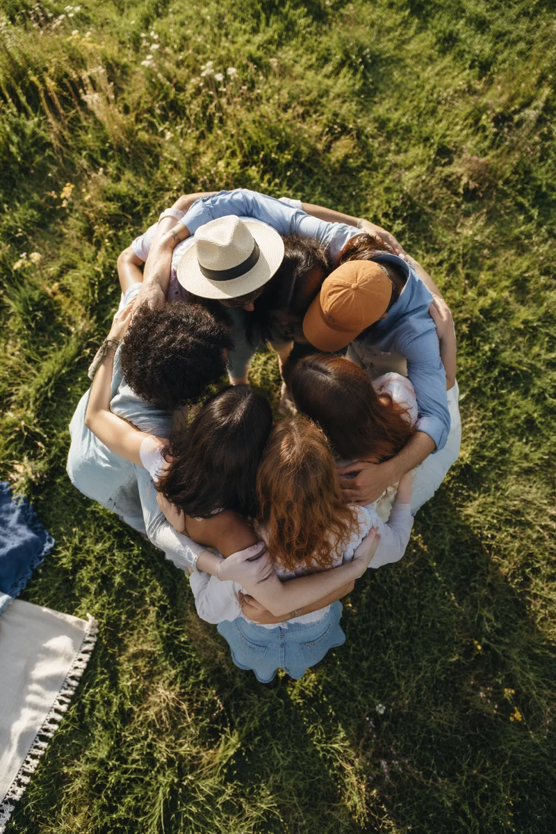 Diverse Friends Hug Circle in Sunny Meadow