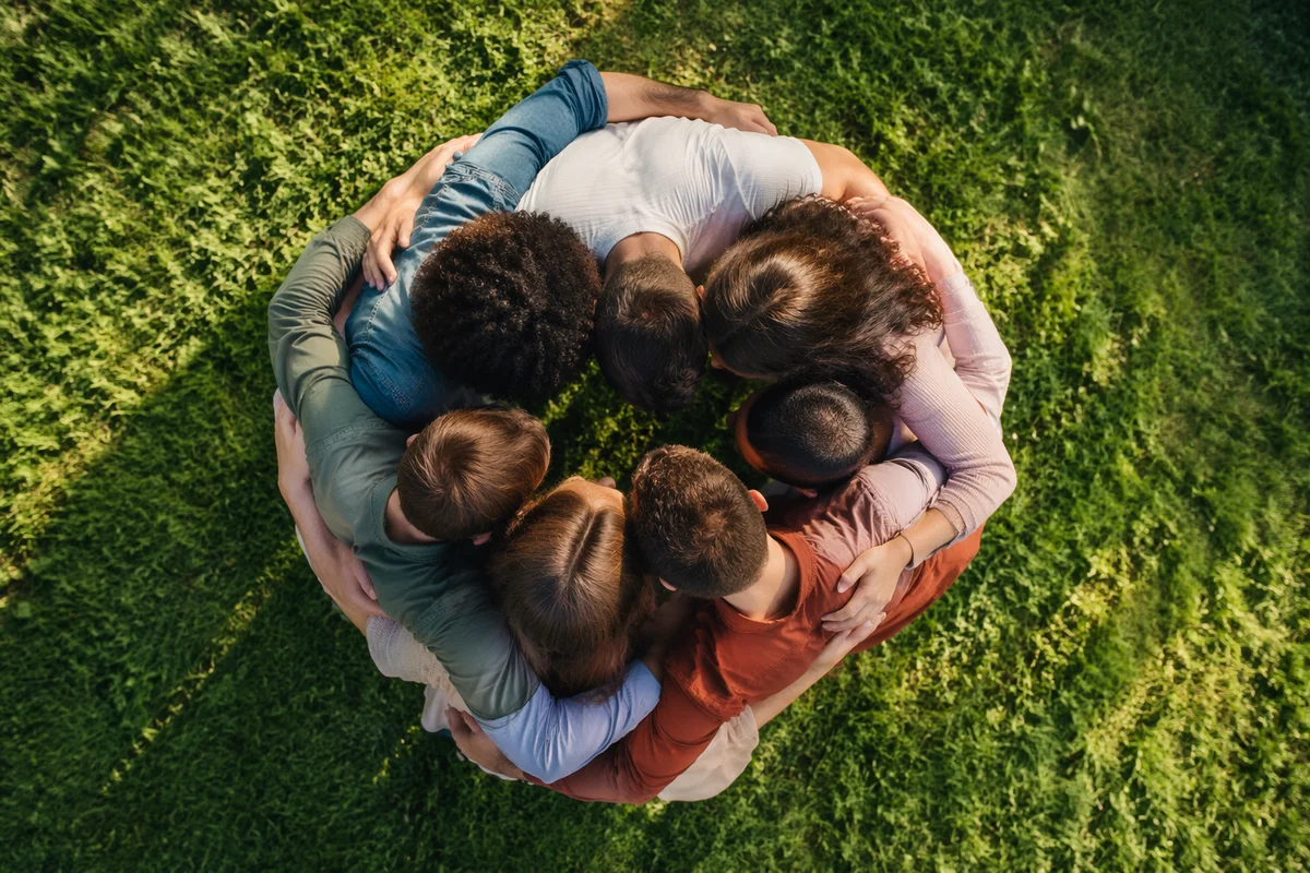 Overhead Friends Group Hug on Sunlit Lawn