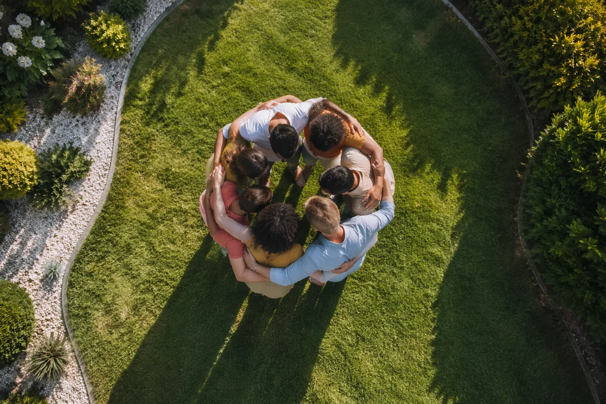 Overhead Friends Group Hug on Green Lawn