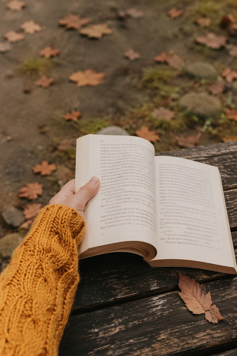 Open Paperback Reading on Autumn Park Bench