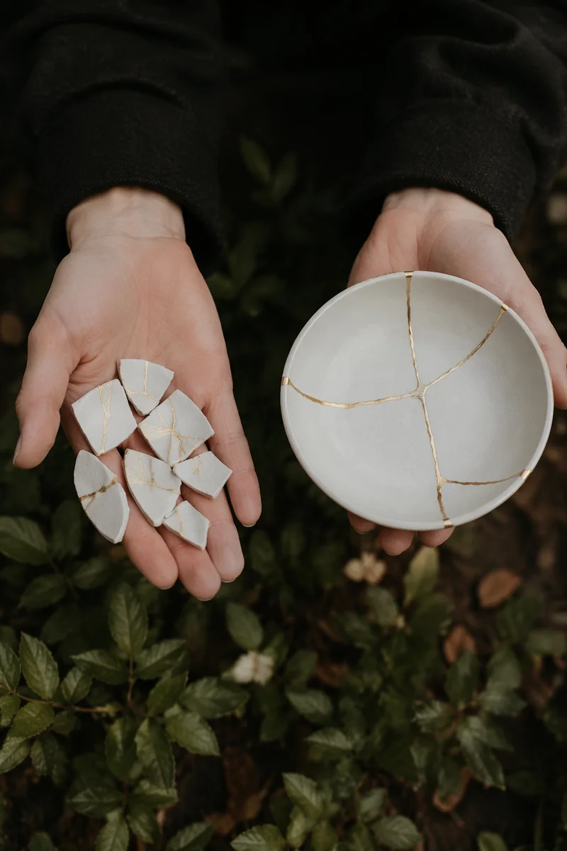 Hands Holding Kintsugi Pottery in Garden