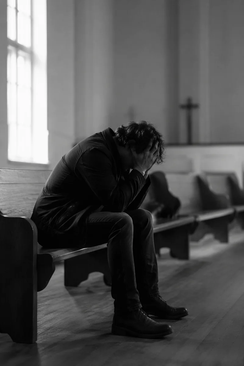 Solitary Man Praying in Quiet Chapel
