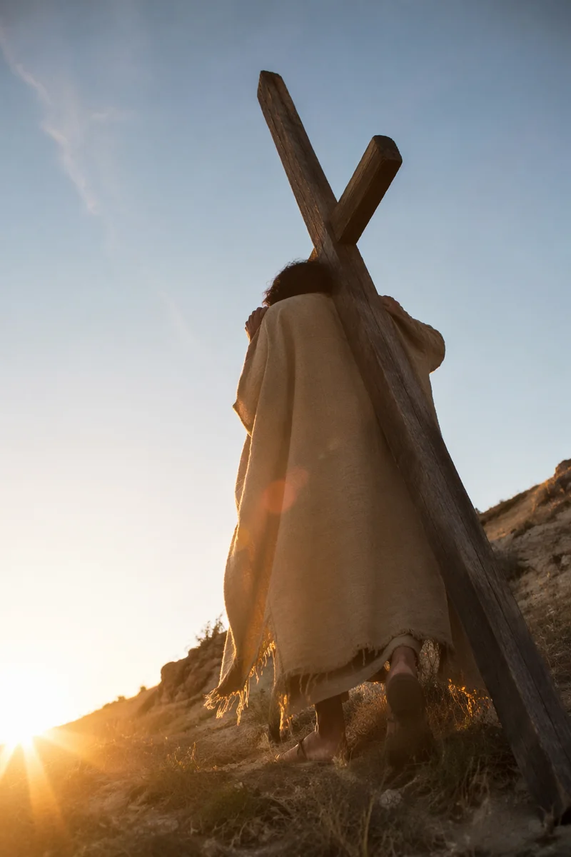 Solitary Figure Carrying Cross Uphill at Sunset