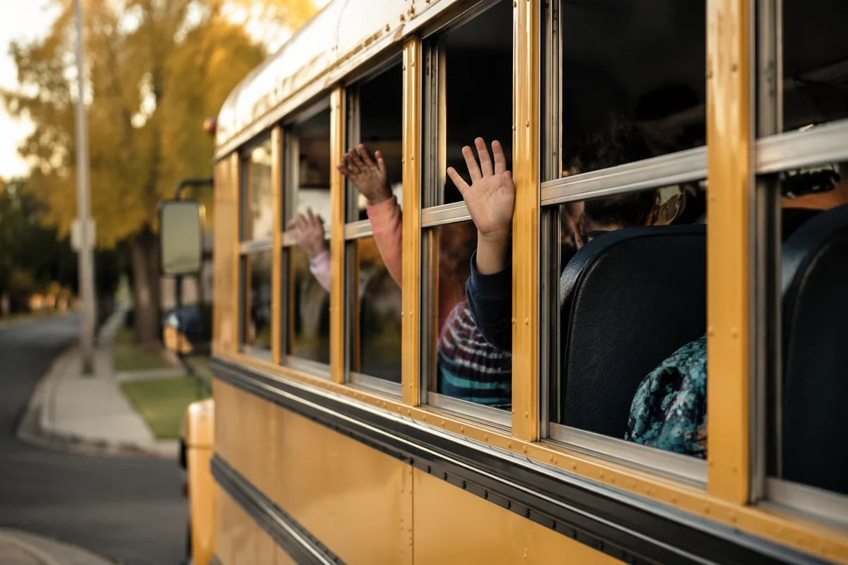 Children Waving From Yellow School Bus