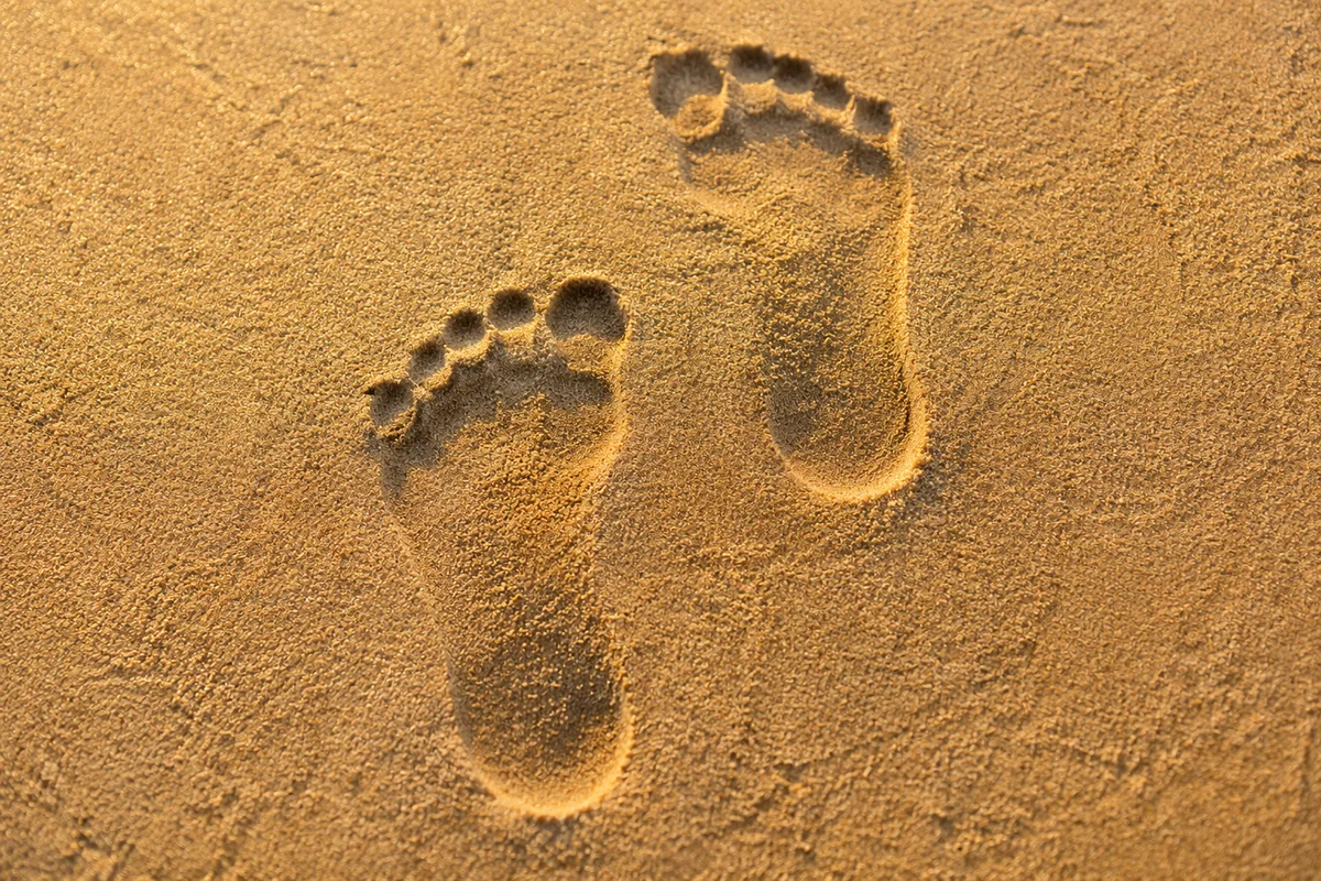 Barefoot Footprints in Golden Sunset Sand