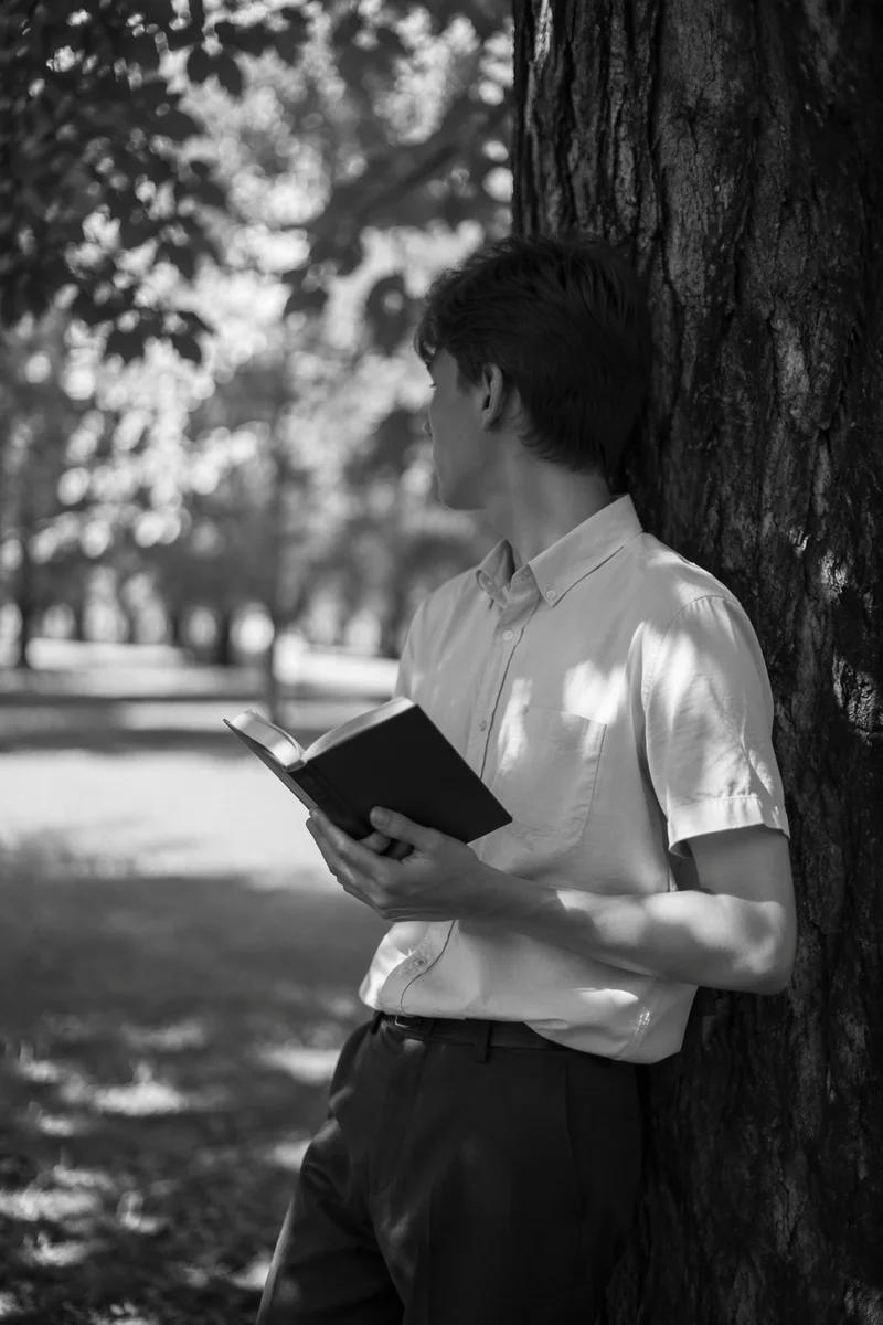 Teen Reading Bible Beneath Tree Shade