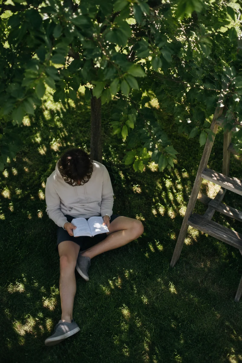 Teen Reading Bible Beneath Garden Tree