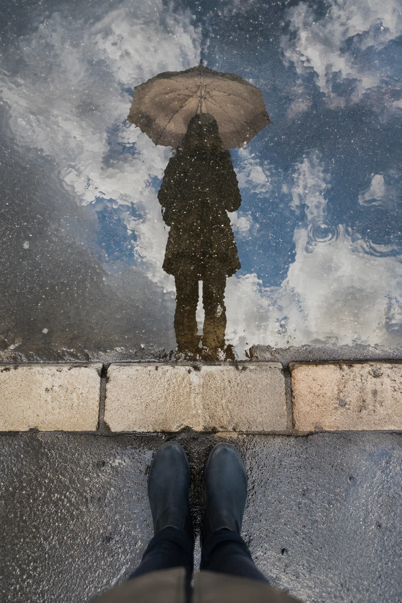 Umbrella Reflection in Rain Puddle Street