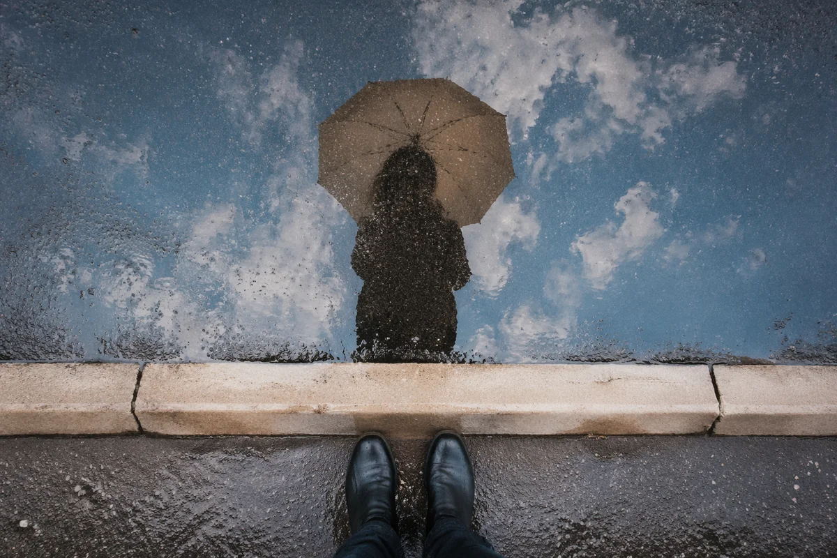 Umbrella Reflection in Rain Puddle Street