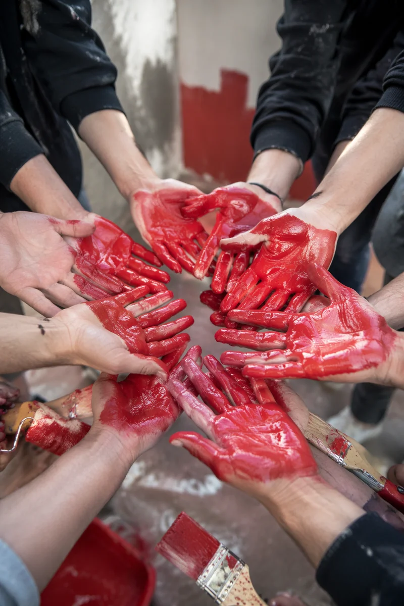 Volunteers Joining Painted Hands for Community Teamwork
