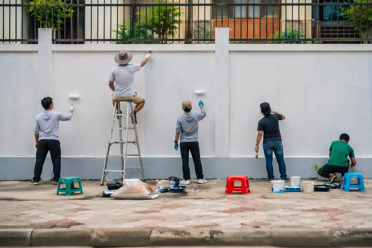 Community Volunteers Painting Neighborhood Wall Together