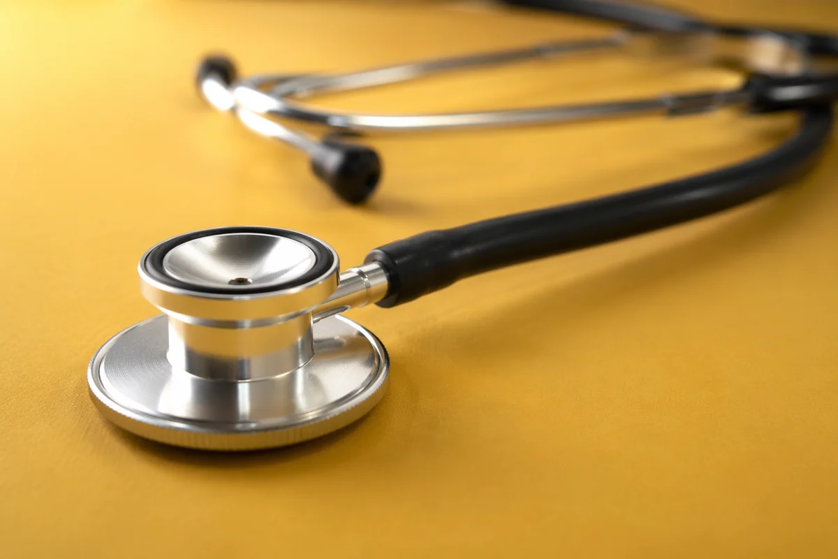 Close-Up Stethoscope on Mustard Yellow Surface