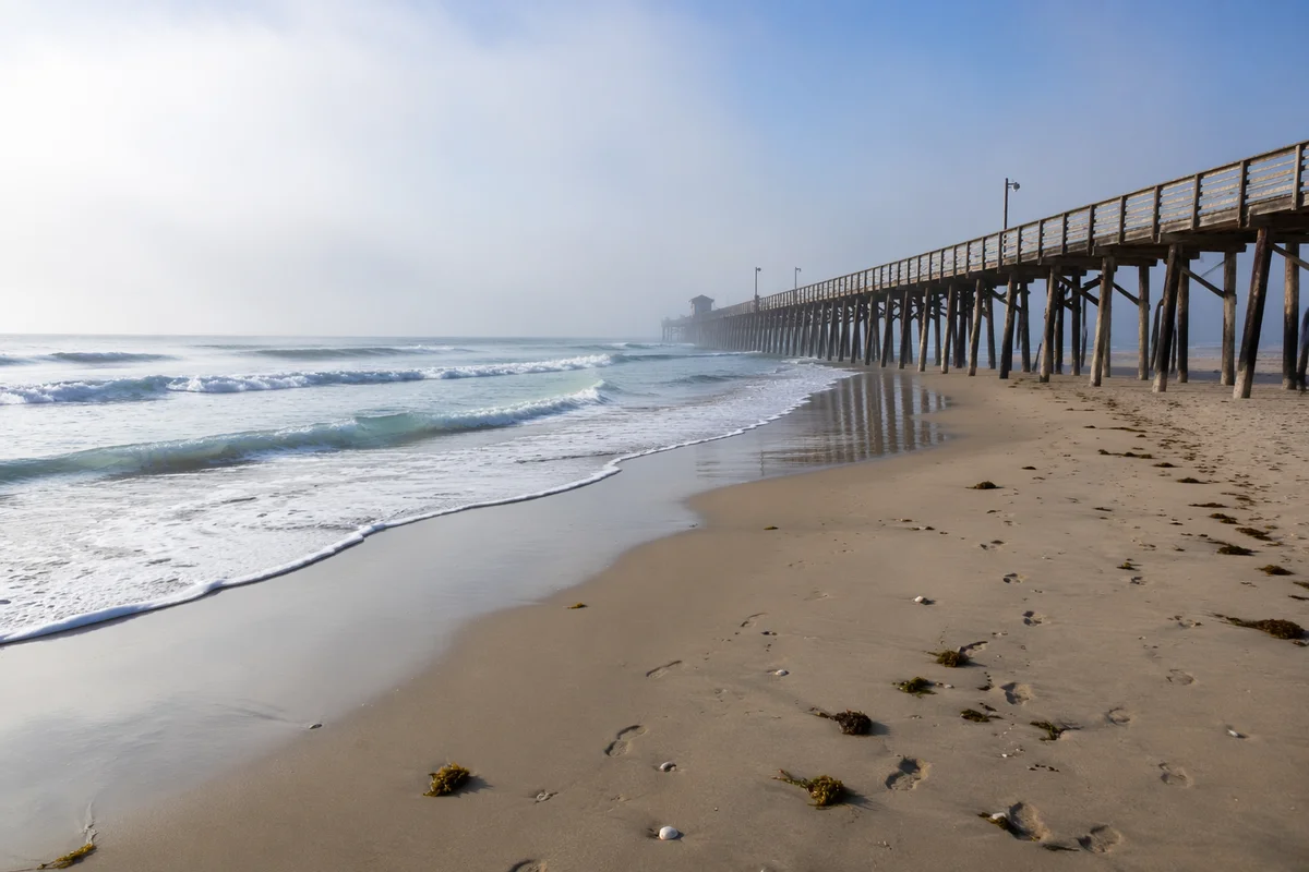 Misty Summer Beach With Wooden Pier