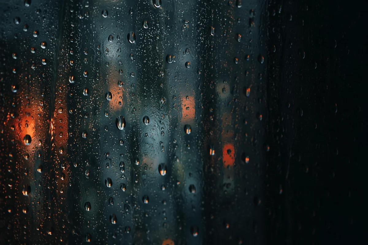 Rain Droplets on Blurred Window at Dusk
