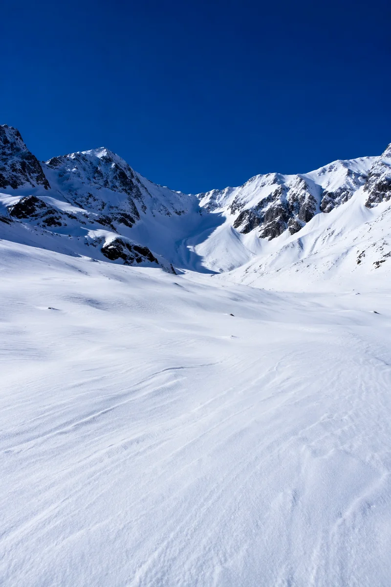 Silent Snowfield Beneath Cobalt Alpine Peaks