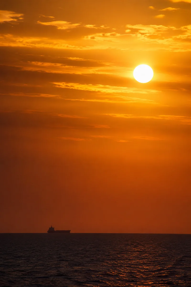 Golden Sunset Ocean Horizon with Distant Vessel