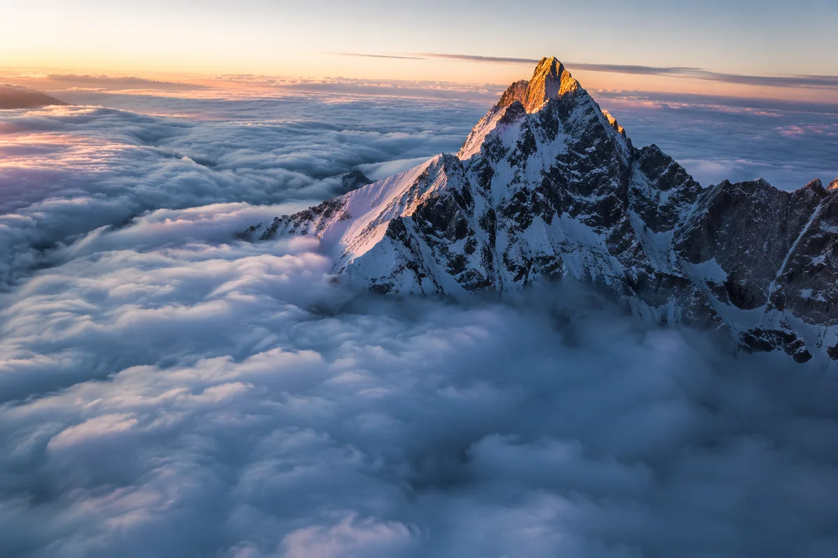 Majestic Mountain Peak Above Ocean Clouds
