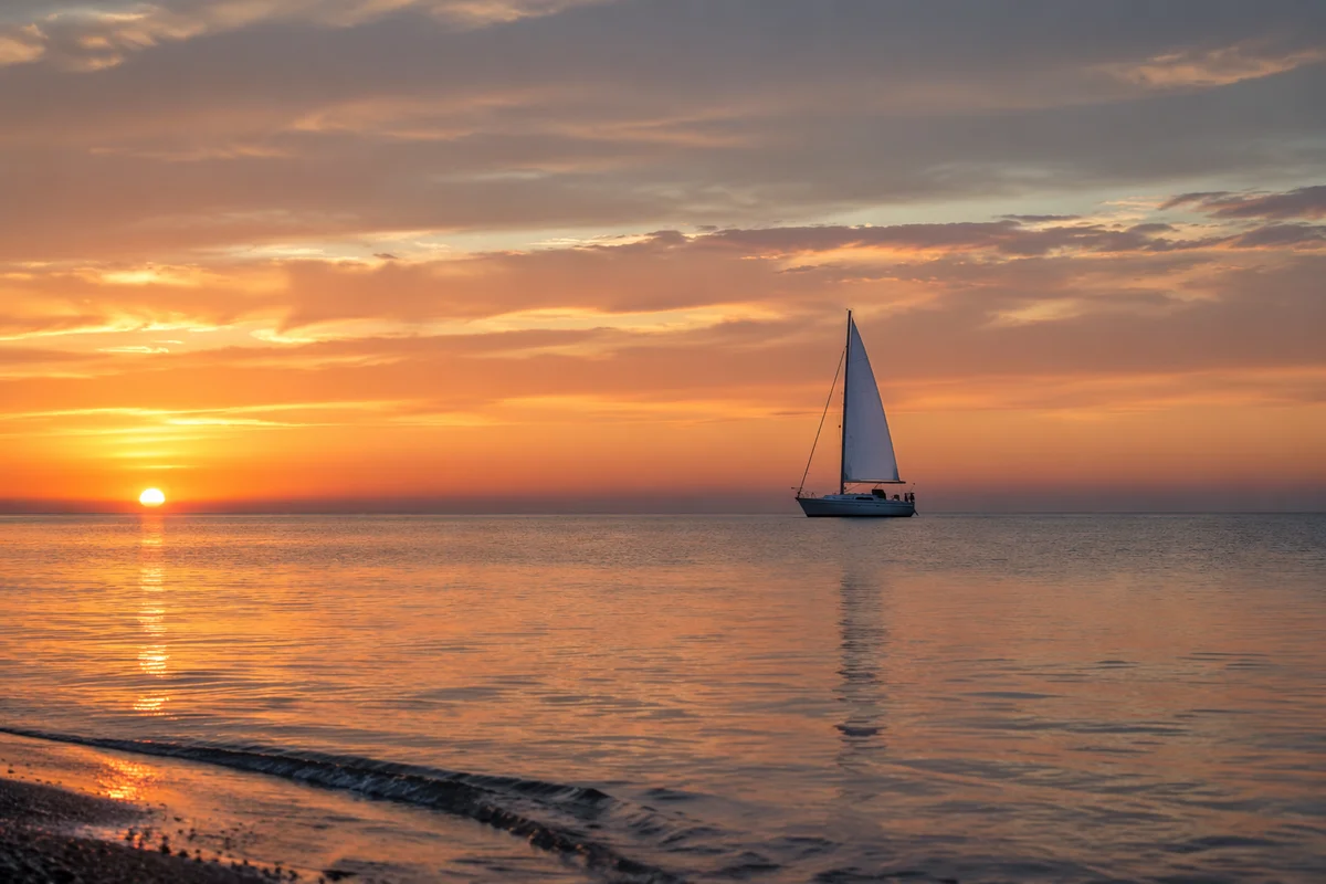 Peaceful Sailboat on Ocean at Sunset