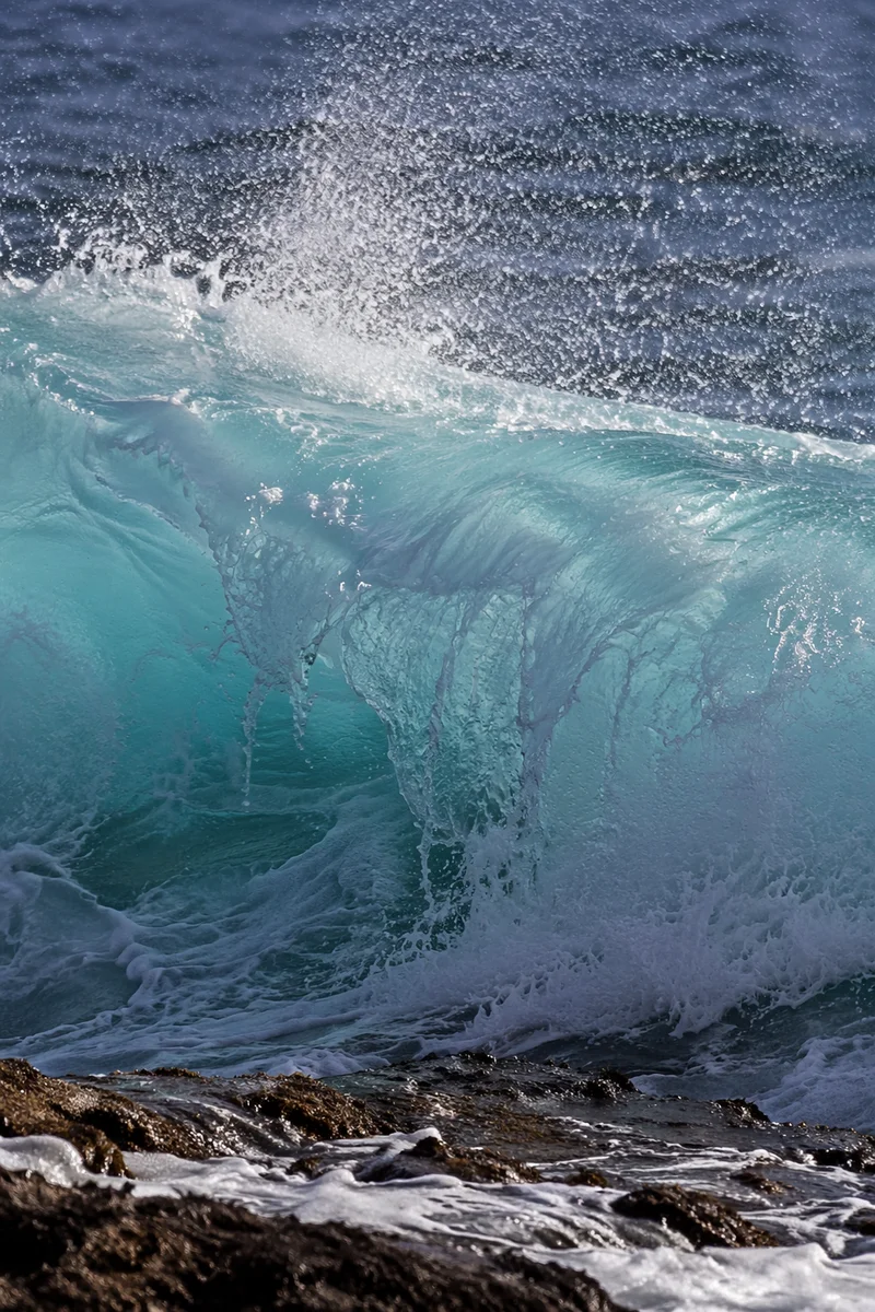 Turquoise Wave Breaking on Coastal Rocks
