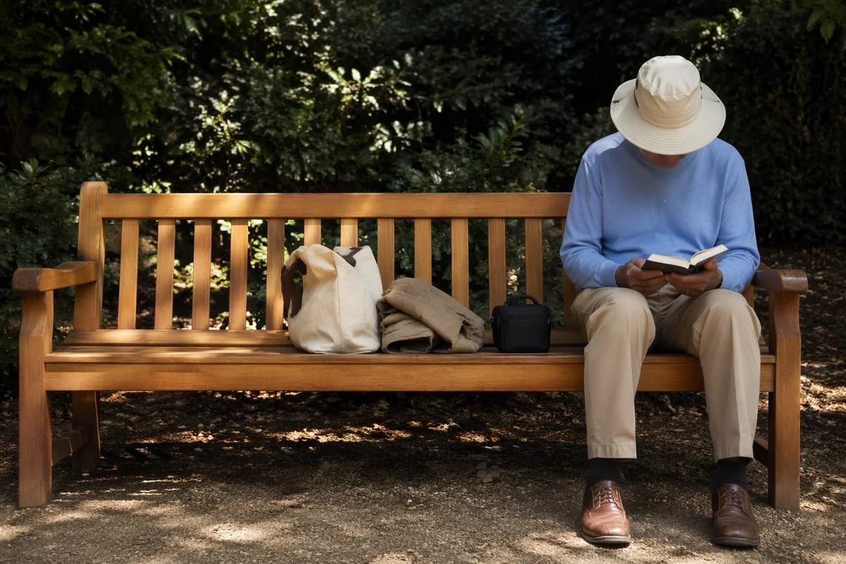 Elderly Asian Man Reading Bible in Park
