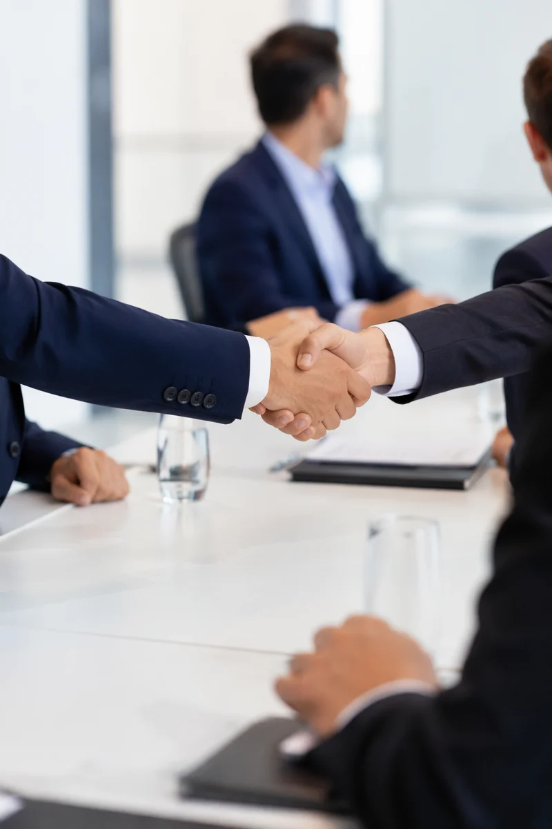 Business Professionals Handshake in Modern Meeting