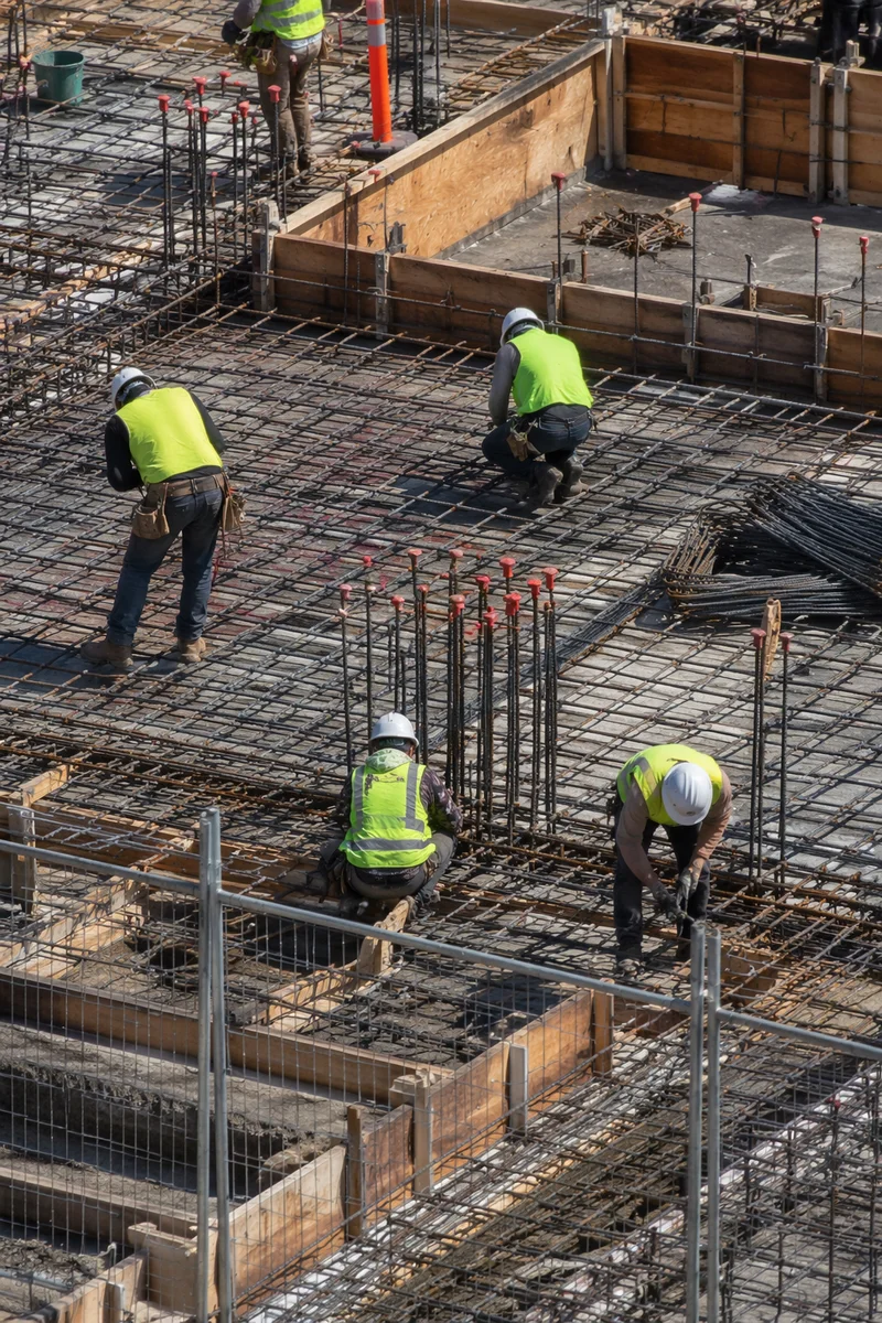 Construction Workers Assembling Rebar on Site