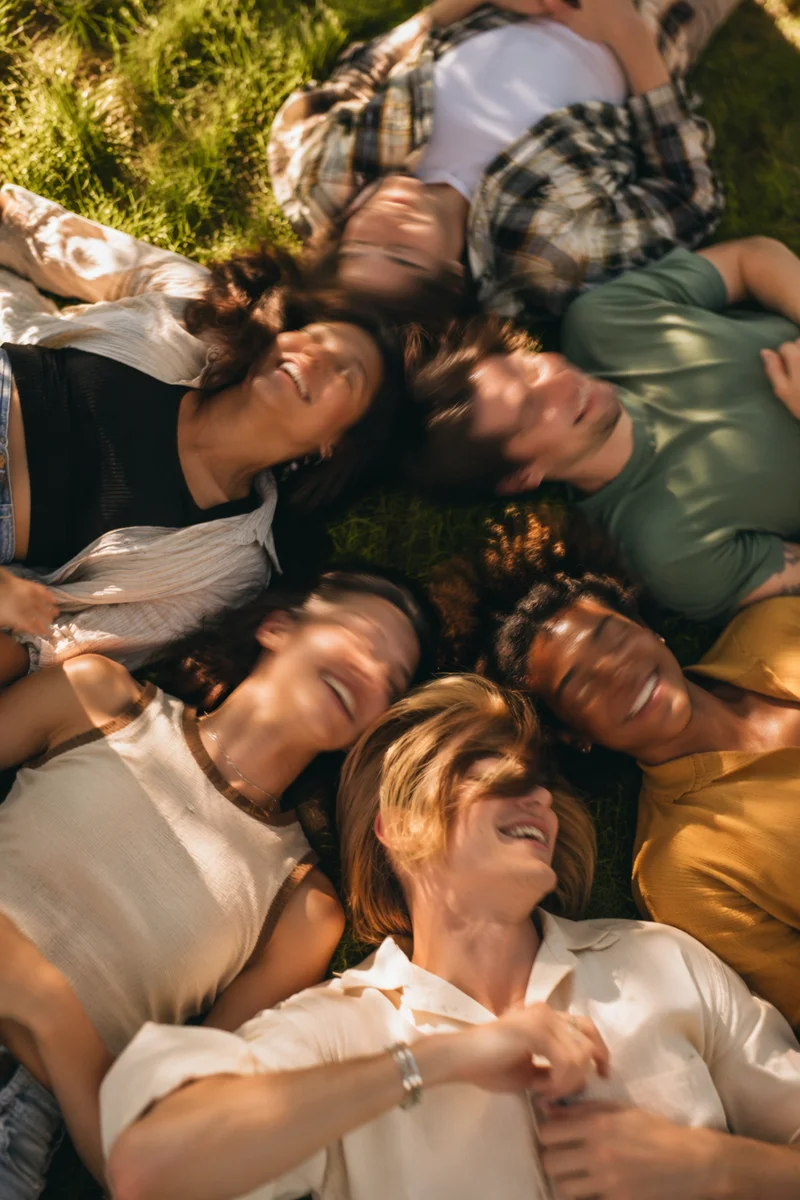 Diverse Friends Laughing on Sunny Grass