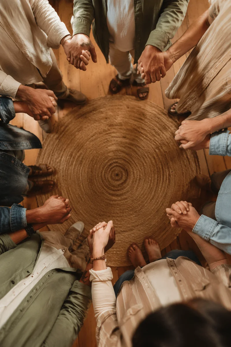 Diverse Prayer Circle Hands in Community Room